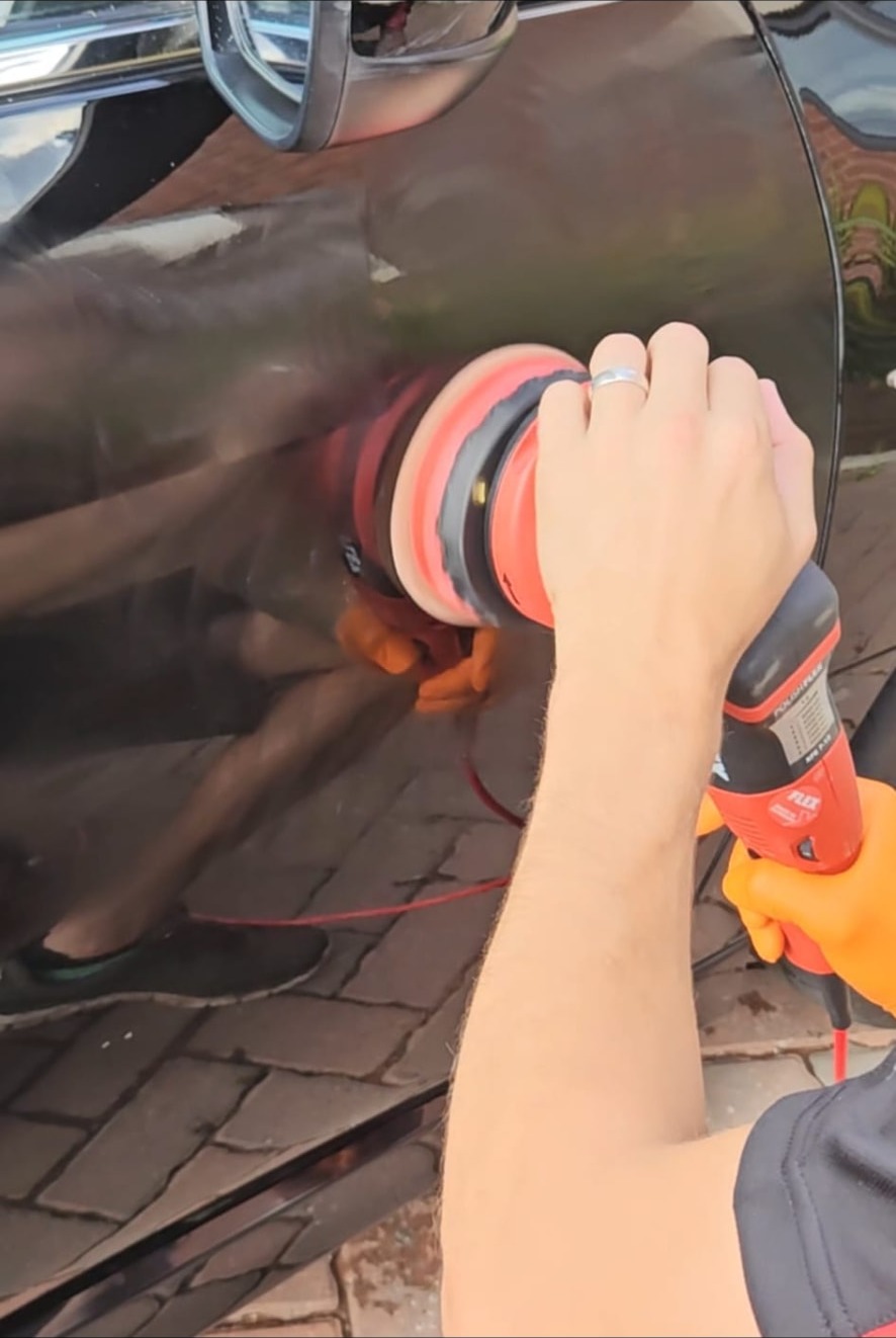 Machine polishing a reflective dark vehicle door
