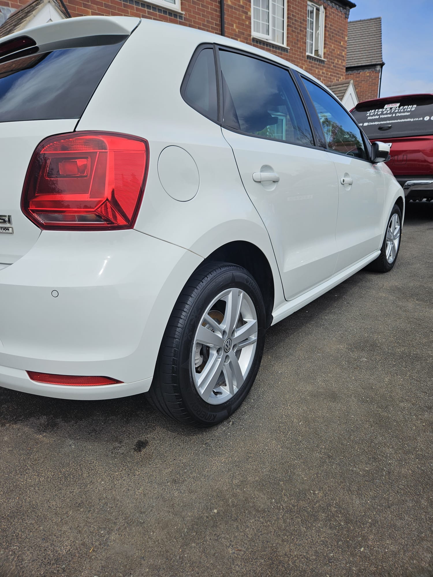 The same white Volkswagen hatchback after exterior cleaning