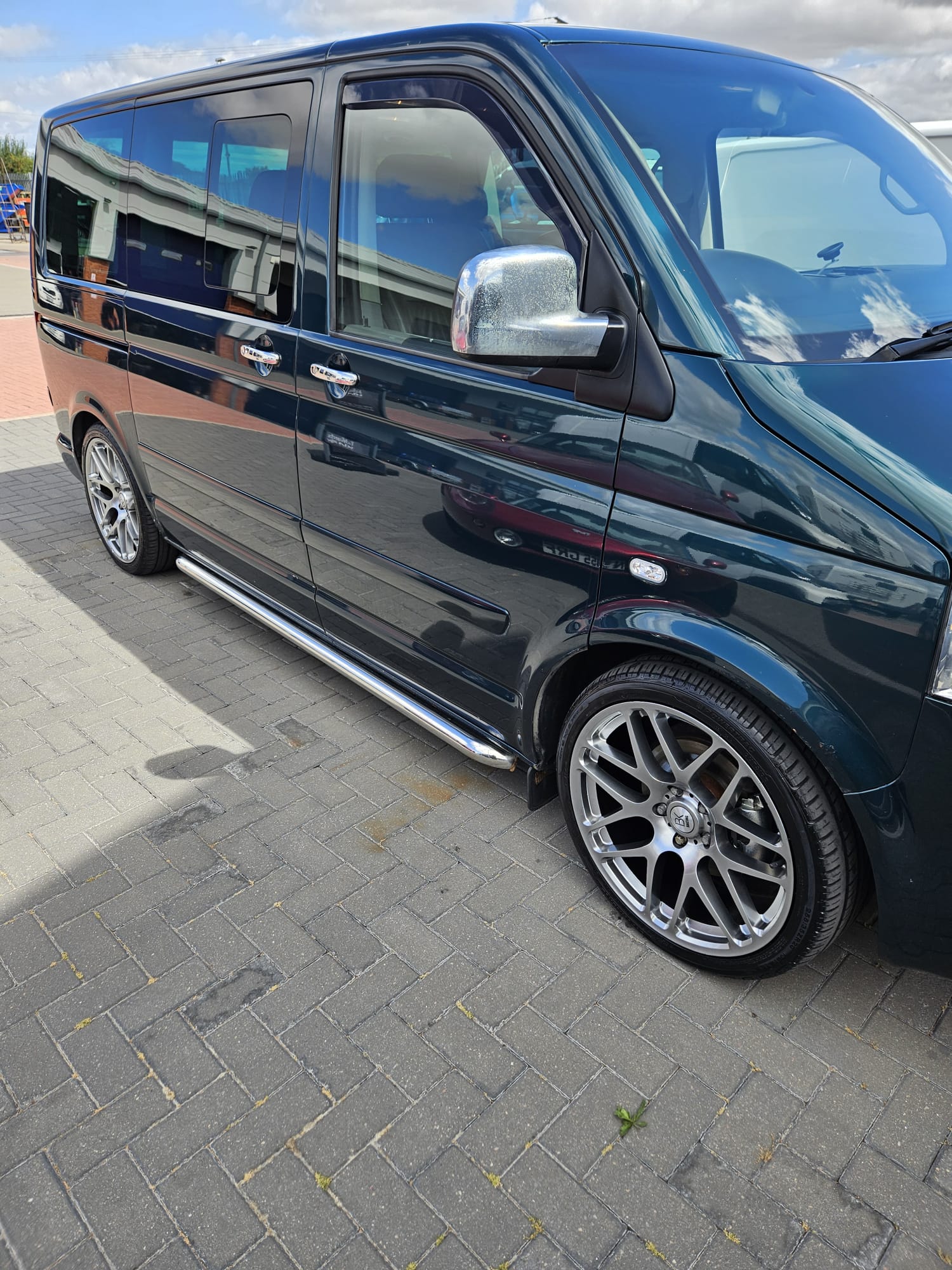 Dark green Volkswagen Transporter cleaned on a block paved driveway