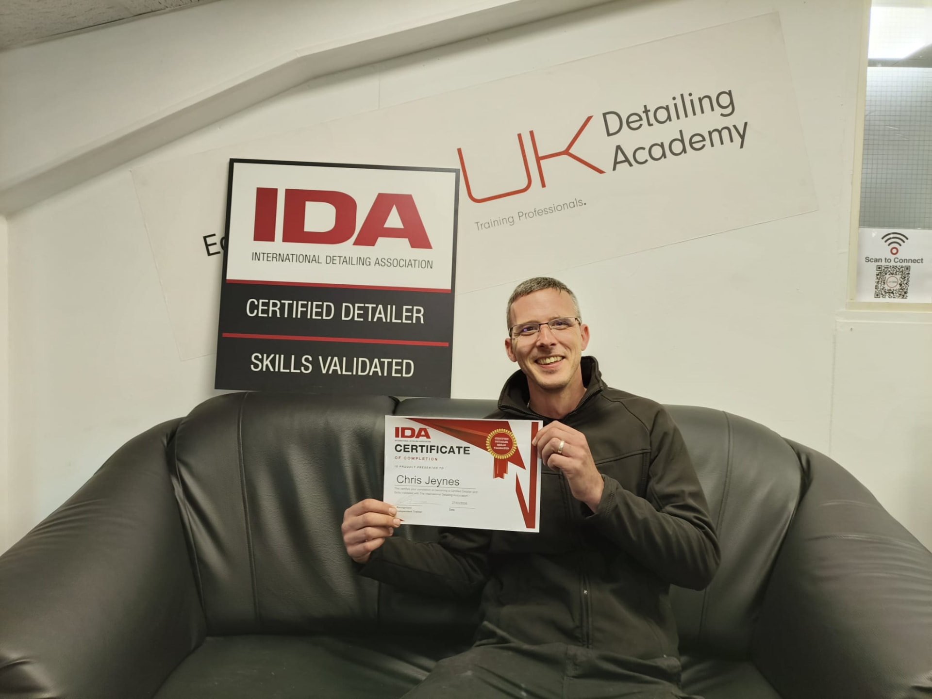 Chris Jeynes holding his IDA Certificate of Completion at the UK Detailing Academy