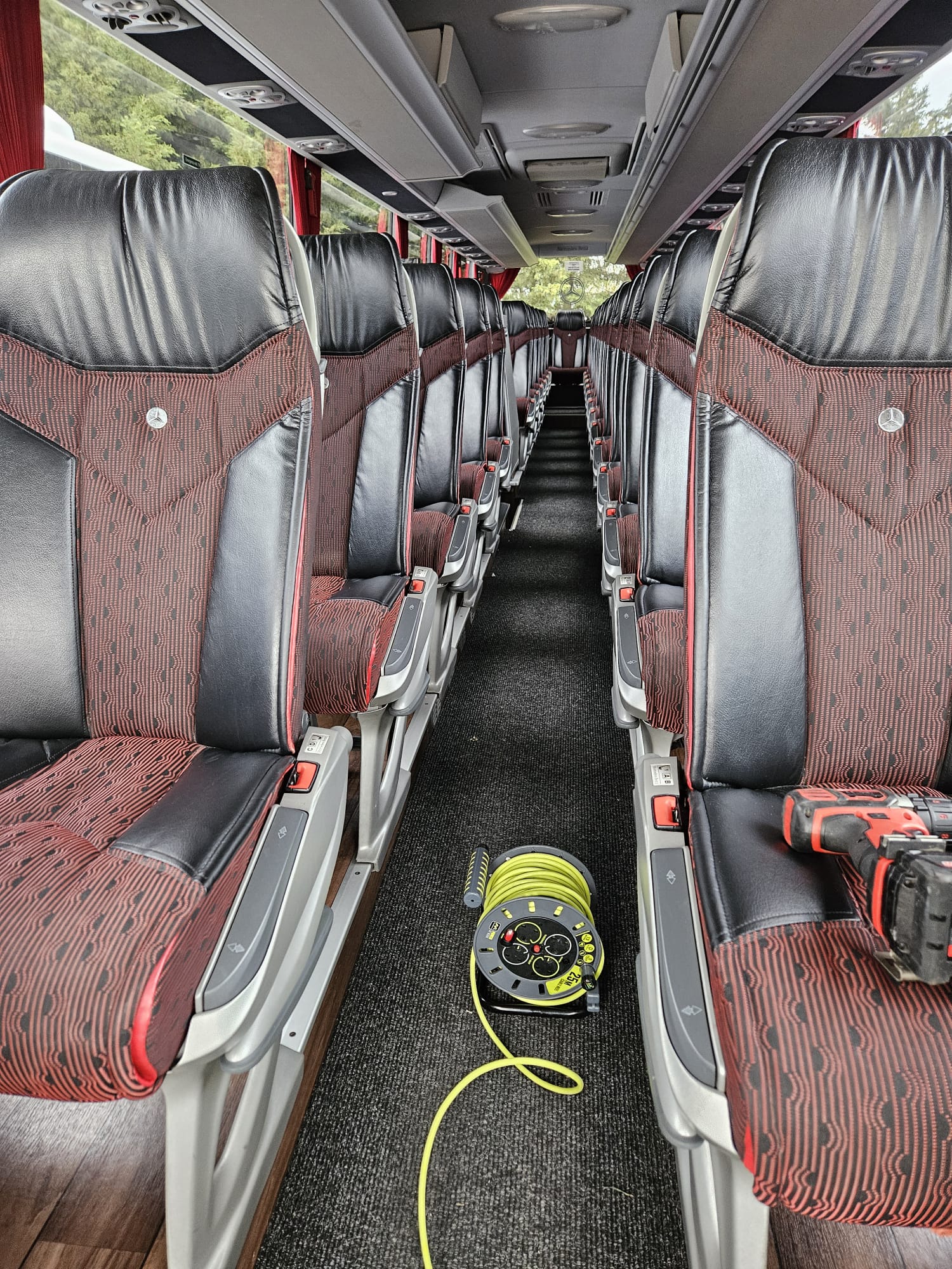 Coach interior with red seats and freshly cleaned aisle carpet
